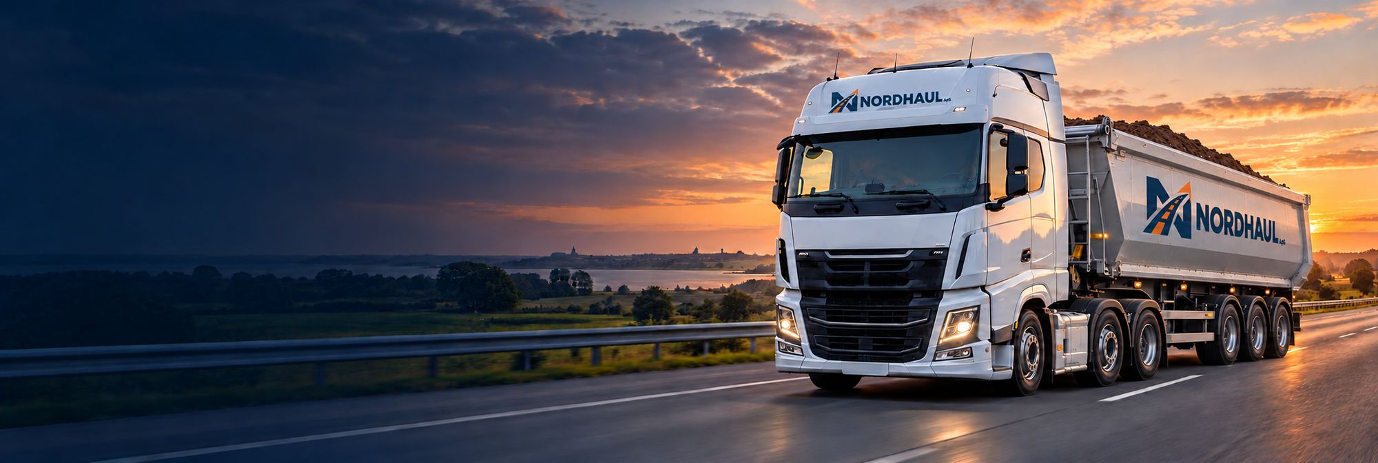 Hvid lastbil med Nordhaul-logo på landevej ved solnedgang
